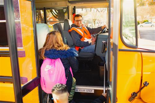 Bus driver greets students
